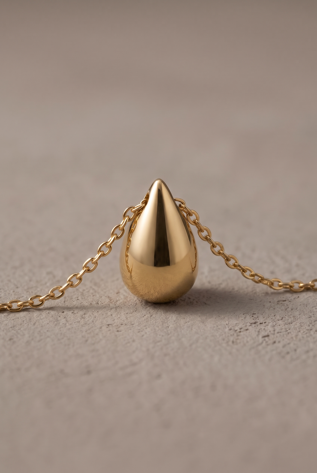 Close-up of the polished teardrop drop threaded on the chain