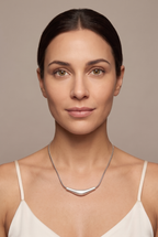 Curved bar pendant snake chain necklace worn at the collarbone