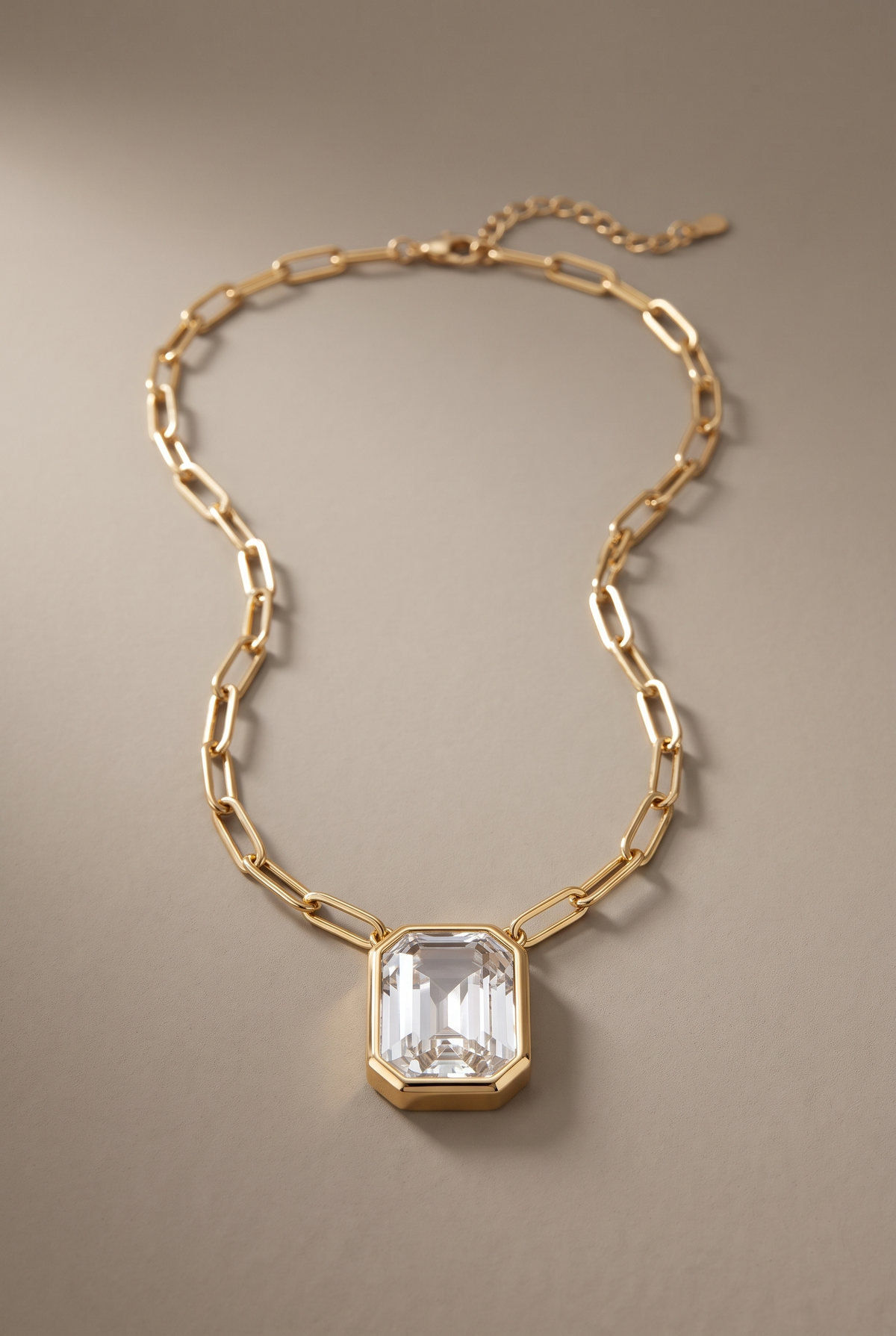 DropIQ emerald-cut clear crystal bezel pendant on a gold paperclip chain