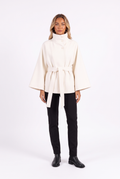 Belted cape jacket with funnel collar in white — front